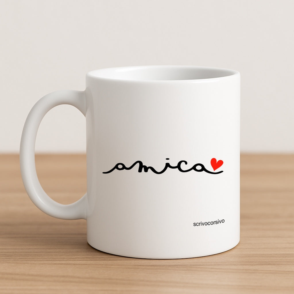 tazza mug calligrafata con la parola “amica” scritta a mano in corsivo nero con un piccolo cuore rosso