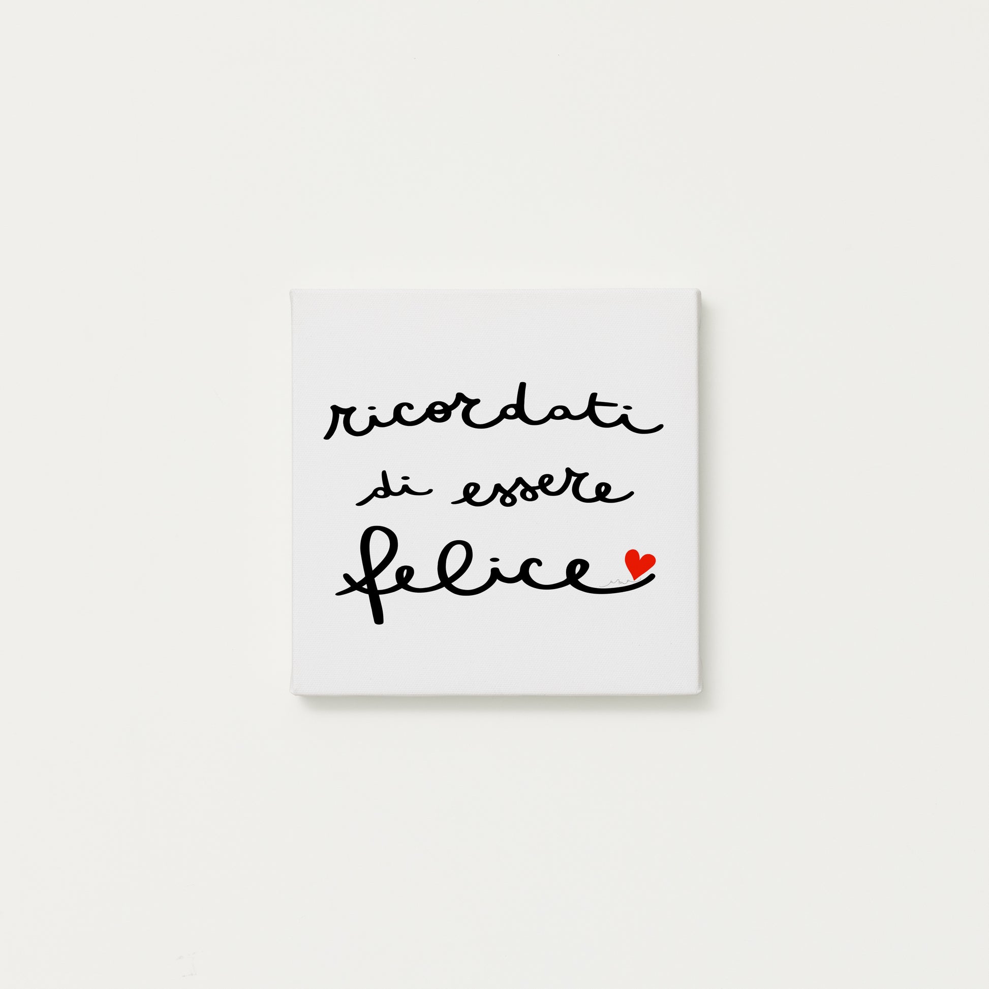 tela calligrafata con la scritta “ricordati di essere felice” scritta a mano in corsivo nero con un piccolo cuore rosso - formato quadrato cm 20x20