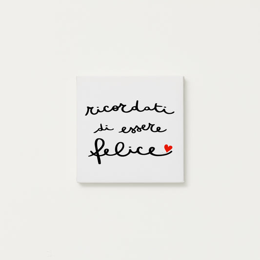 tela calligrafata con la scritta “ricordati di essere felice” scritta a mano in corsivo nero con un piccolo cuore rosso - formato quadrato cm 20x20