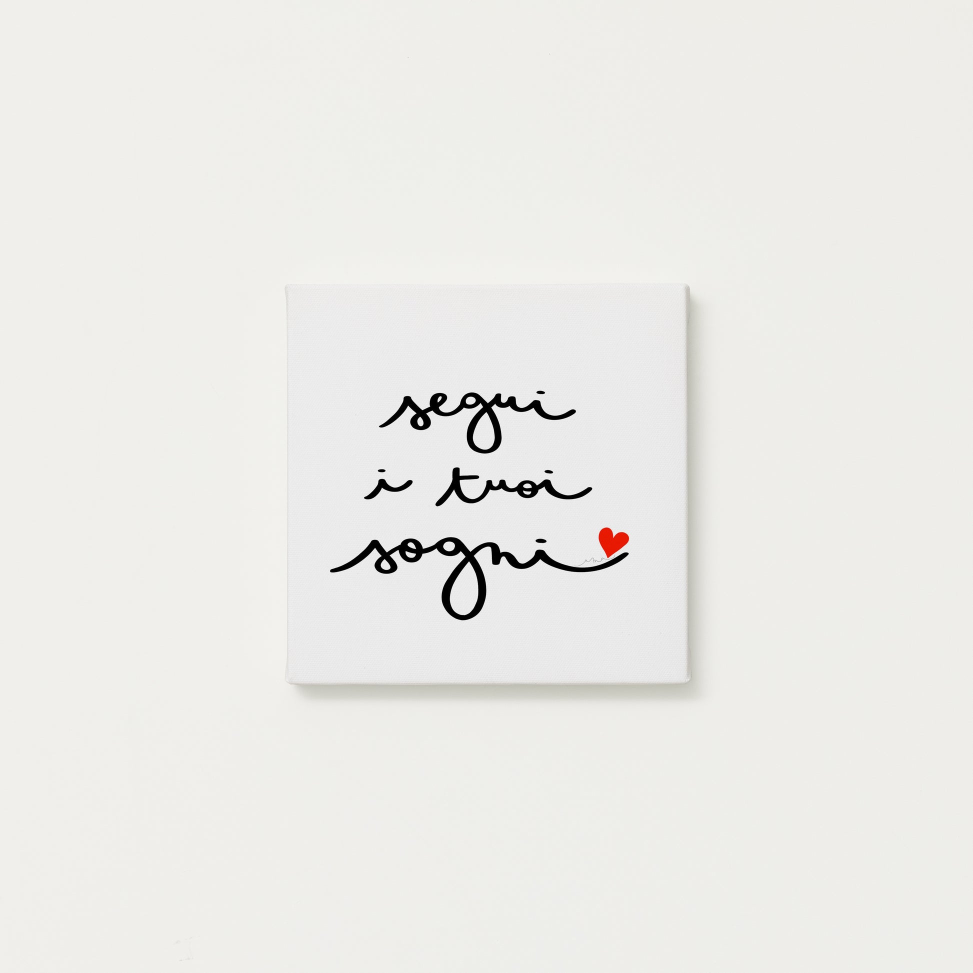 tela calligrafata con la scritta “segui i tuoi sogni” scritta a mano in corsivo nero con un piccolo cuore rosso - formato quadrato cm 20x20