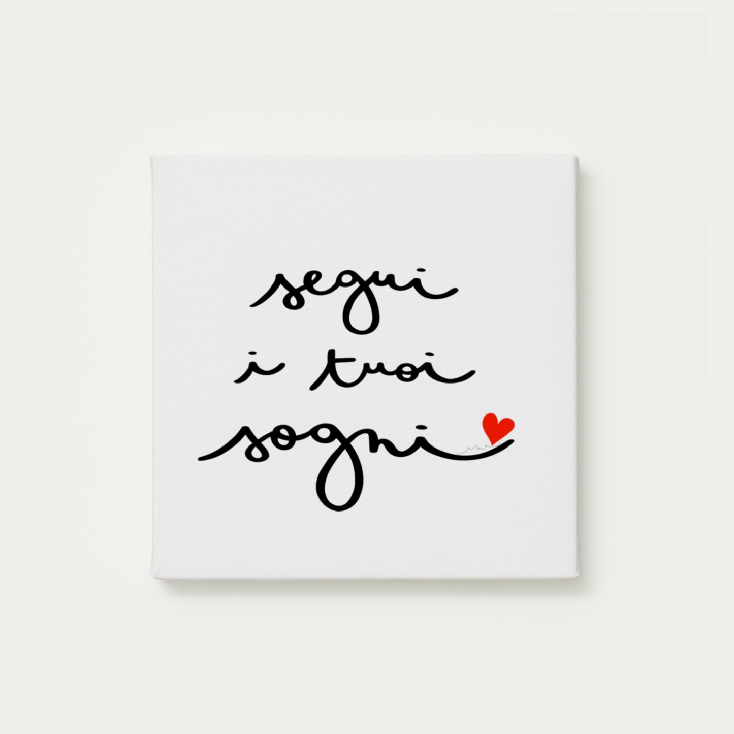 tela calligrafata con la scritta “segui i tuoi sogni” scritta a mano in corsivo nero con un piccolo cuore rosso - formato quadrato cm 30x30